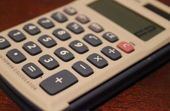 Calculadora e documentos sobre uma secretária de contabilidade